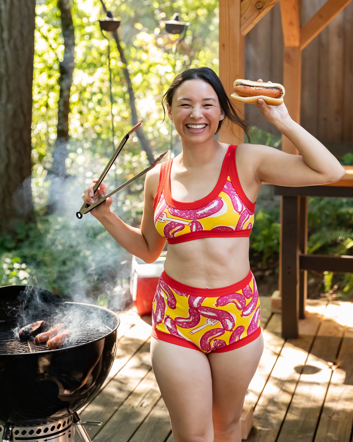 Model wearing Thunderpants Sky Rise style underwear and Bralette in Hot Dawg! print - pink sausages on yellow background and red binding.