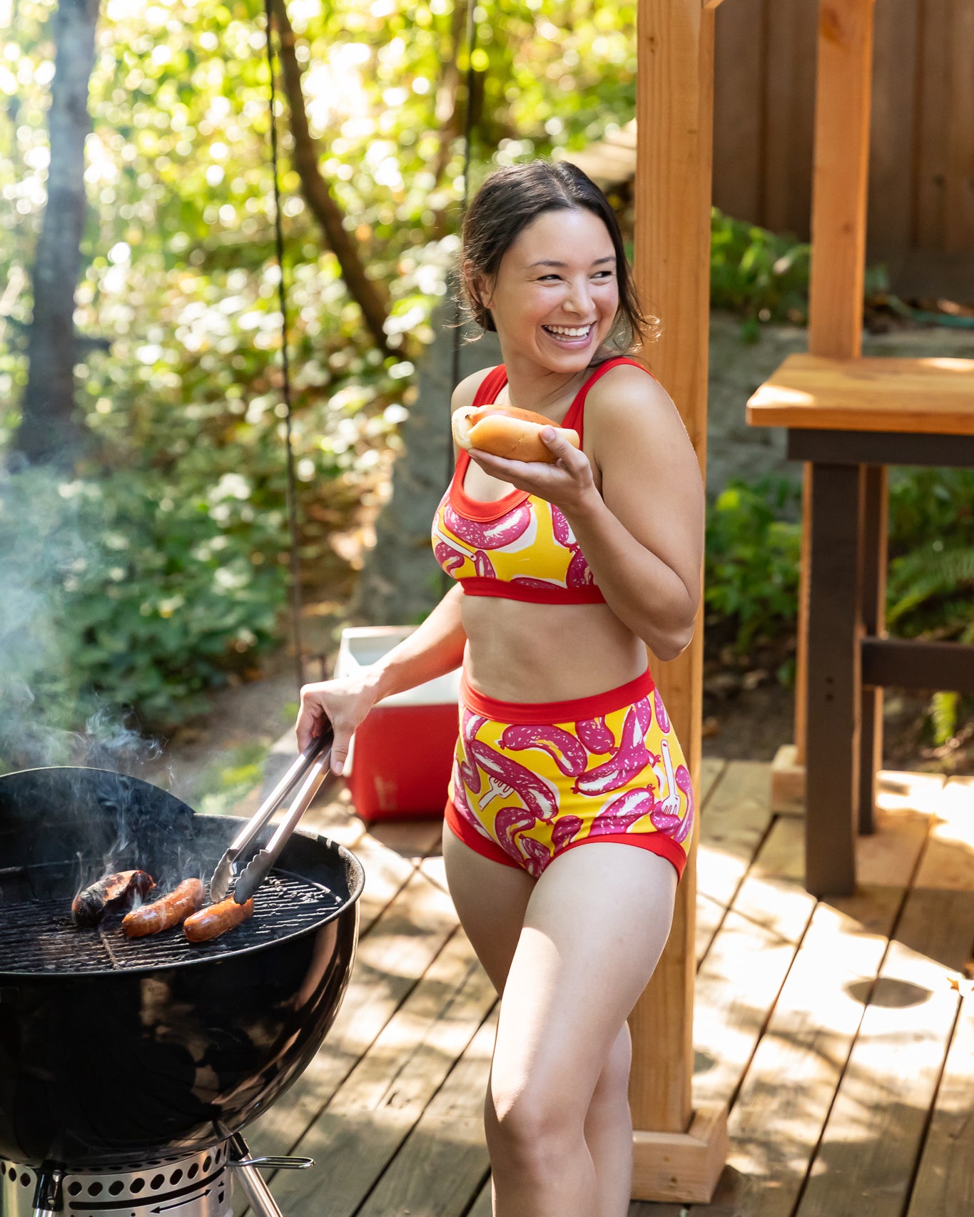 Models wearing Thunderpants Sky Rise style underwear and Bralette in Hot Dawg! print - pink sausages on yellow background and red binding.