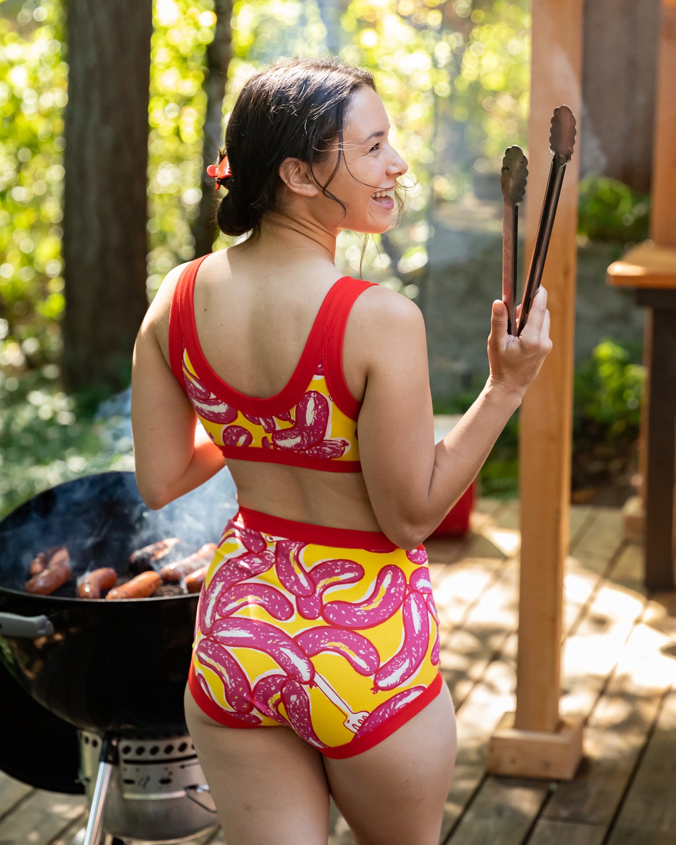 Models wearing Thunderpants Sky Rise style underwear and Bralette in Hot Dawg! print - pink sausages on yellow background and red binding.
