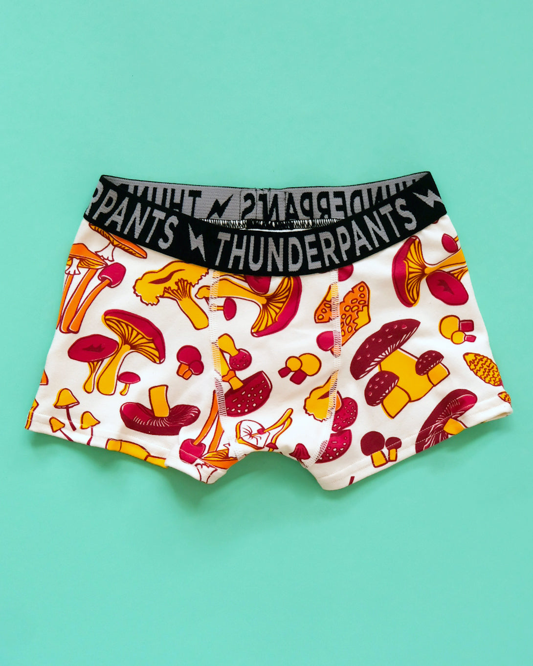 Flat lay of Thunderpants Kids Boxer Brief style underwear in Mushroom print - red, orange, and yellow. 