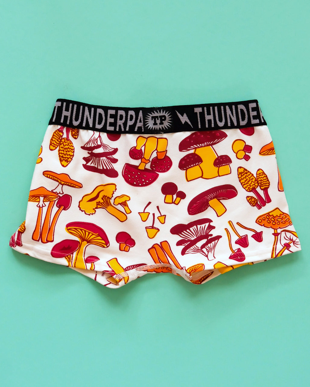 Flat lay of Thunderpants Kids Boxer Brief style underwear in Mushroom print - red, orange, and yellow. 