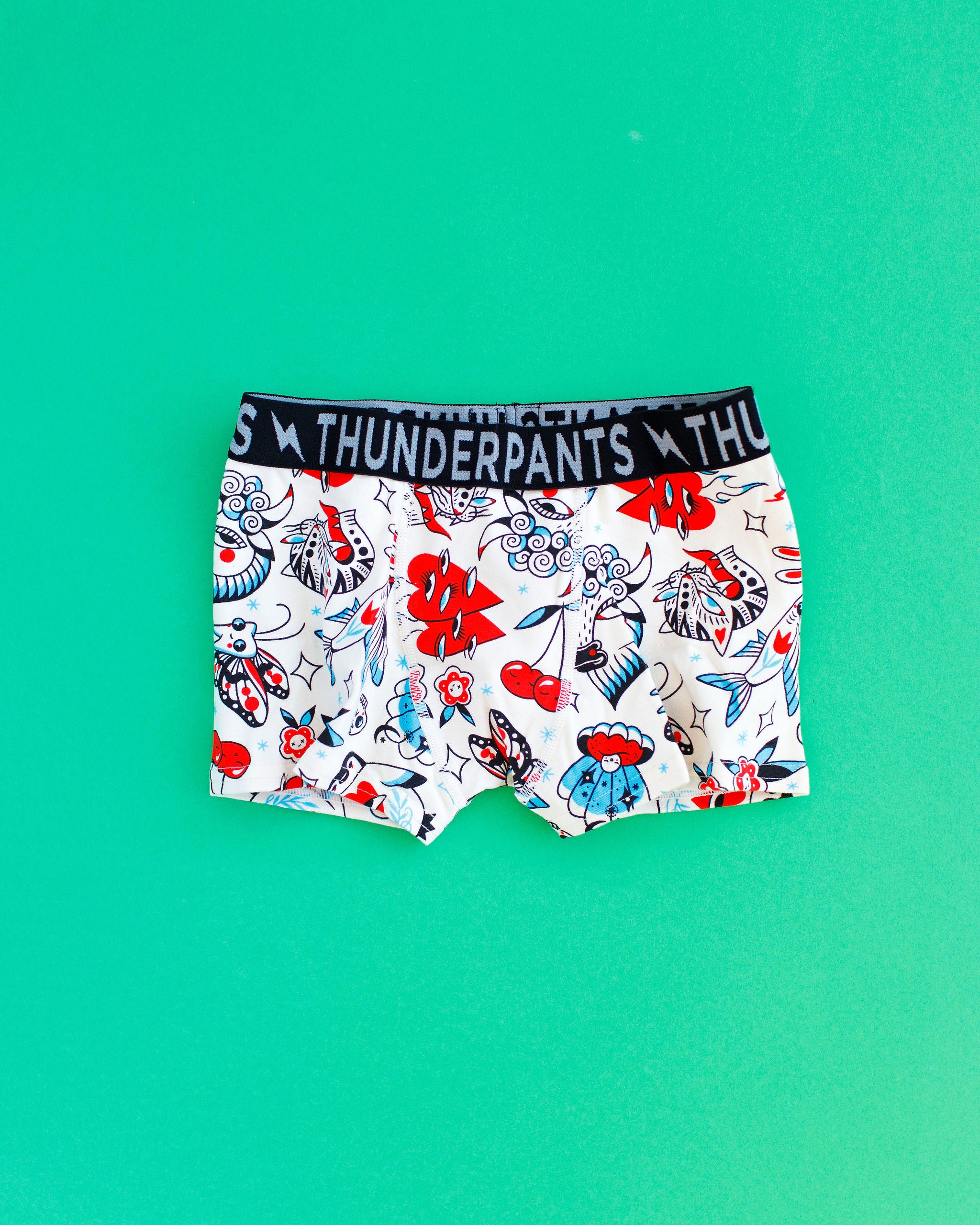 Flat lay of Kids Boxer Brief style underwear in Inked Up - red, blue, and black tattoos.