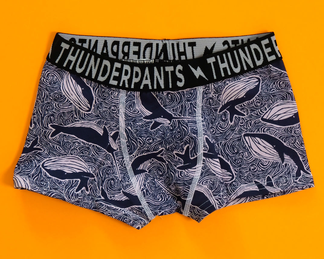 Flat lay of Thunderpants Kids Boxer Brief style underwear in Whale print - blue on purple.