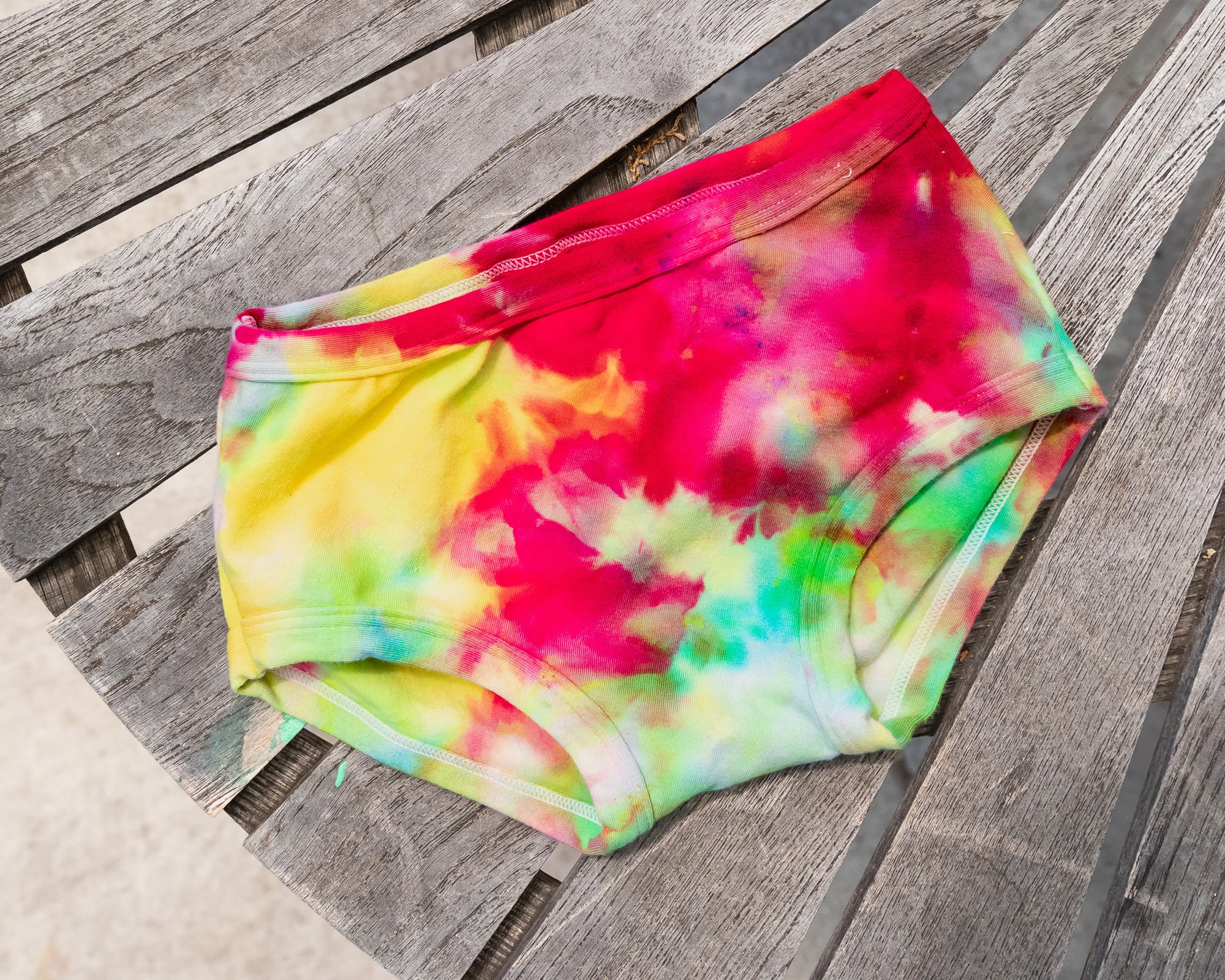 Flat lay of Thunderpants Kid's style underwear in Summer Crush Ice Dye - pinks, blues, yellows. 