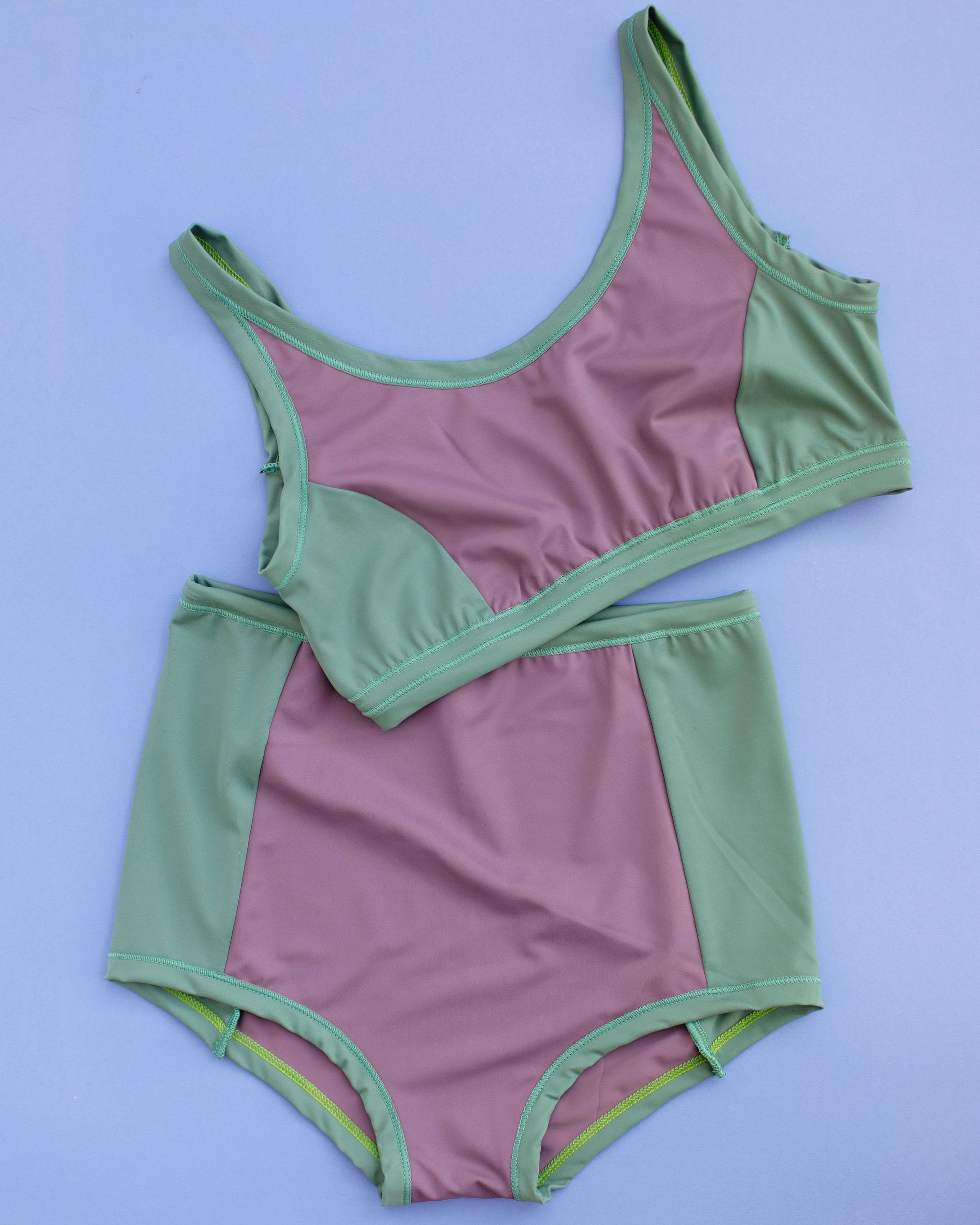 Flat lay of Swimwear Sky Rise Panel Bottom and Swim Panel Top in lavender and lichen green.