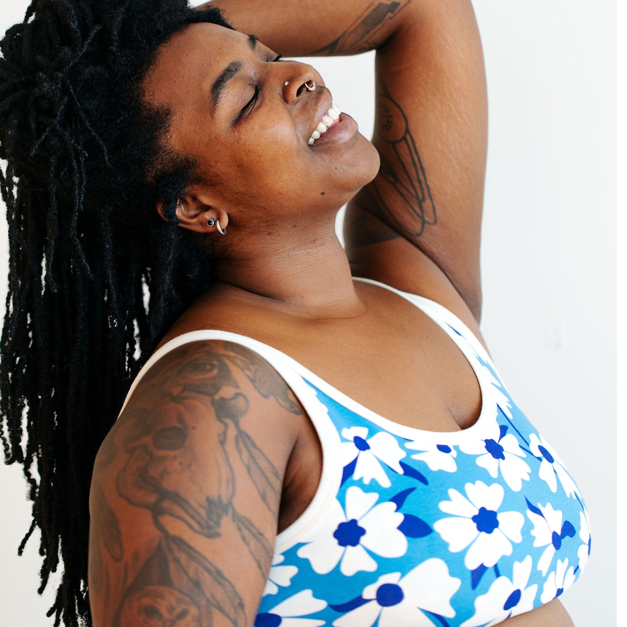 Model wearing Thunderpants Longline Bra in Moody Blooms - white and blue flowers with blue background.