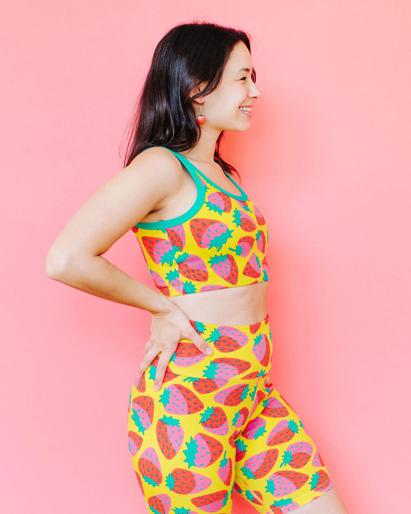 Model wearing Thunderpants Longline Bra in a Strawberry print - pink, red, and peacock green on chartreuse. 