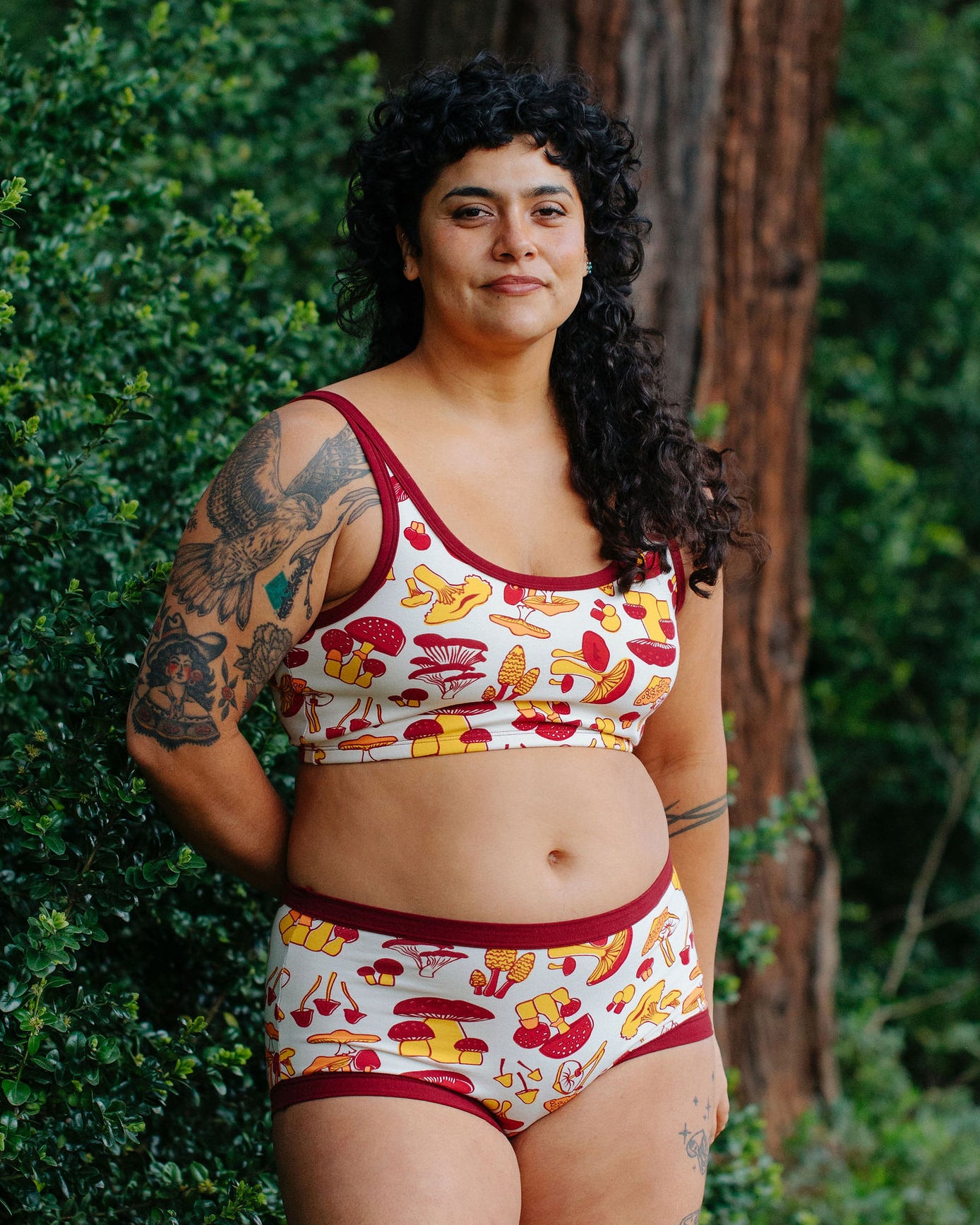 A model wearing Thunderpants Longline Bra and Original style underwear in Whadda Fungi - red, yellow, and orange mushroom print.