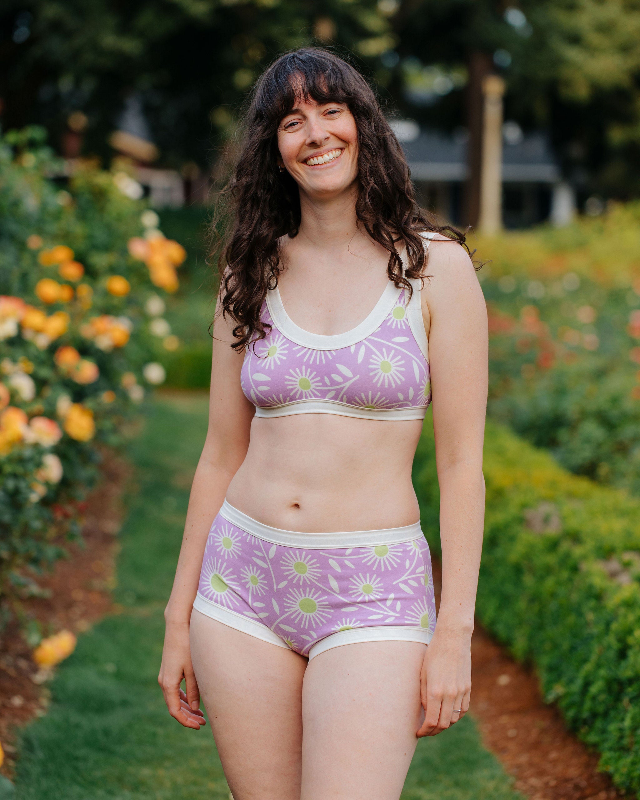 Model wearing Thunderpants Original style underwear and Bralette in Delia's Daisy - white, green, and purple daisies print.