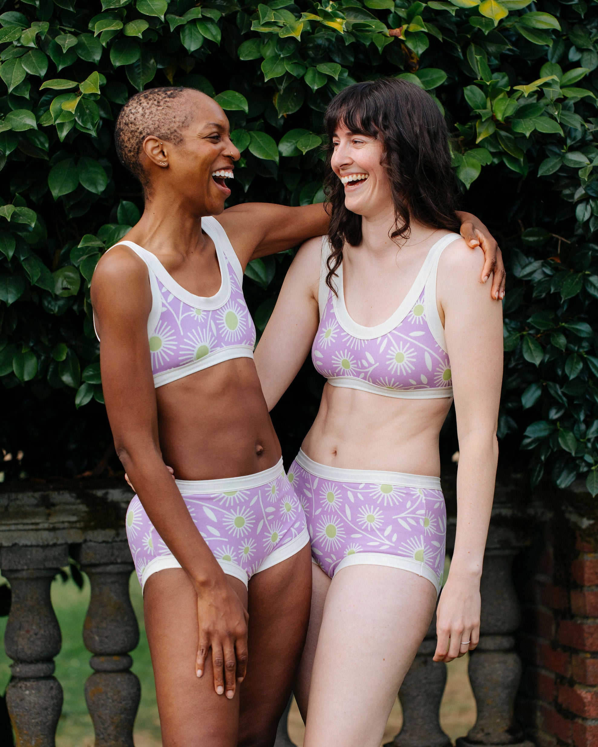 Models wearing Thunderpants Original style underwear and Bralettes in Delia's Daisy - white, green, and purple daisies print.