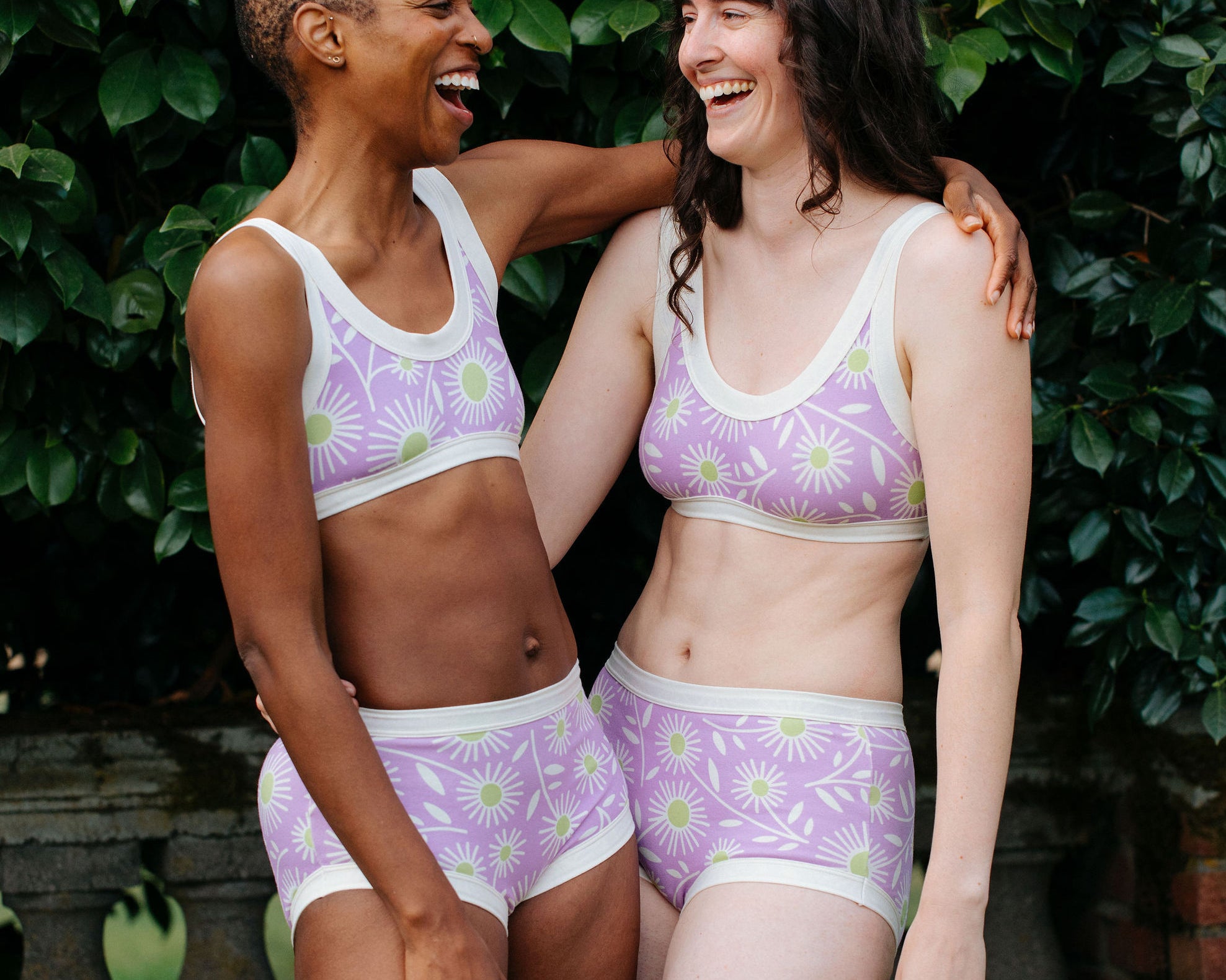 Models wearing Thunderpants Original style underwear and Bralettes in Delia's Daisy - white, green, and purple daisies print.