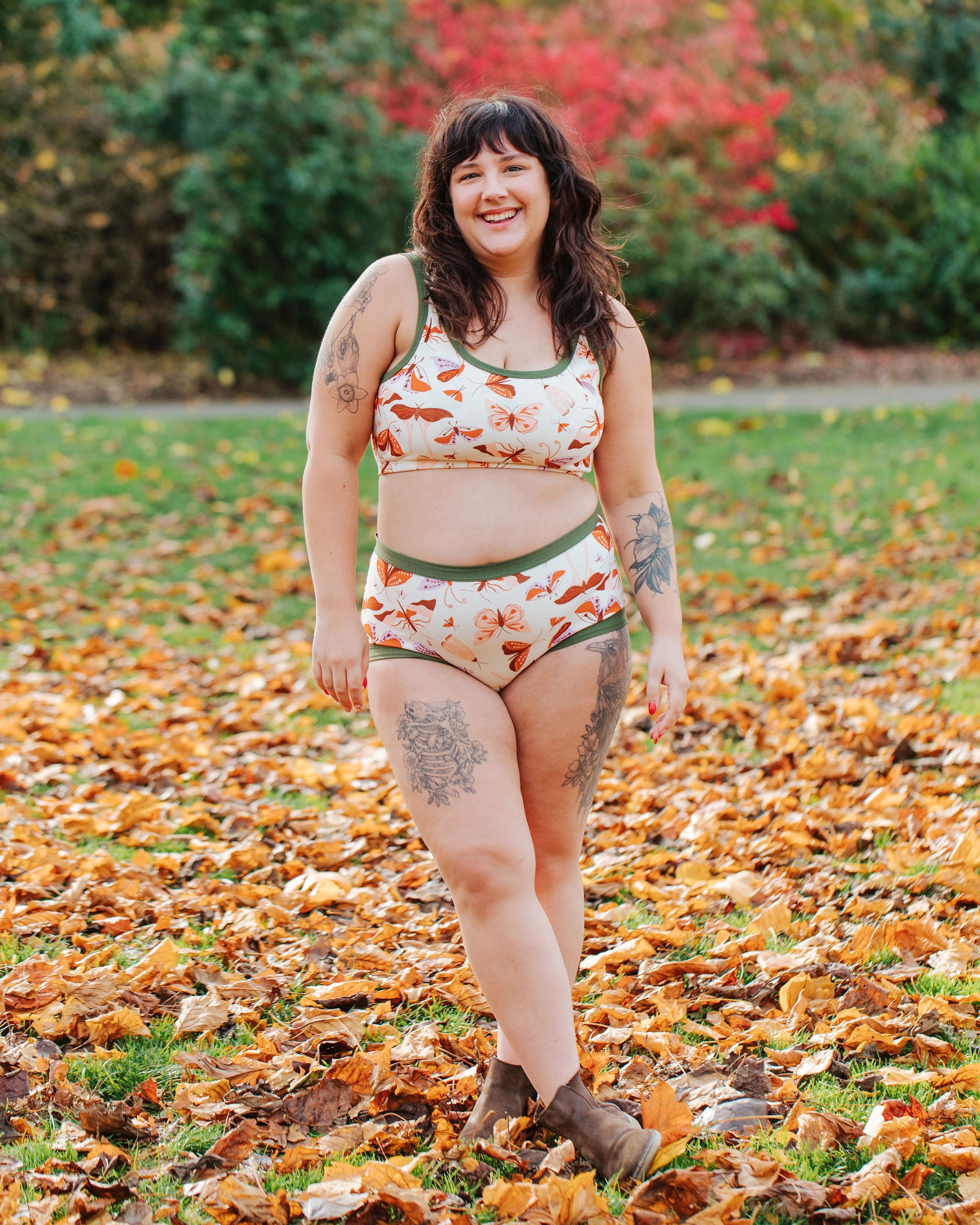 Model wearing Thunderpants Original style underwear and Longline Bra in Field Study: a moth print in red, orange, pink, and purple bound in green.