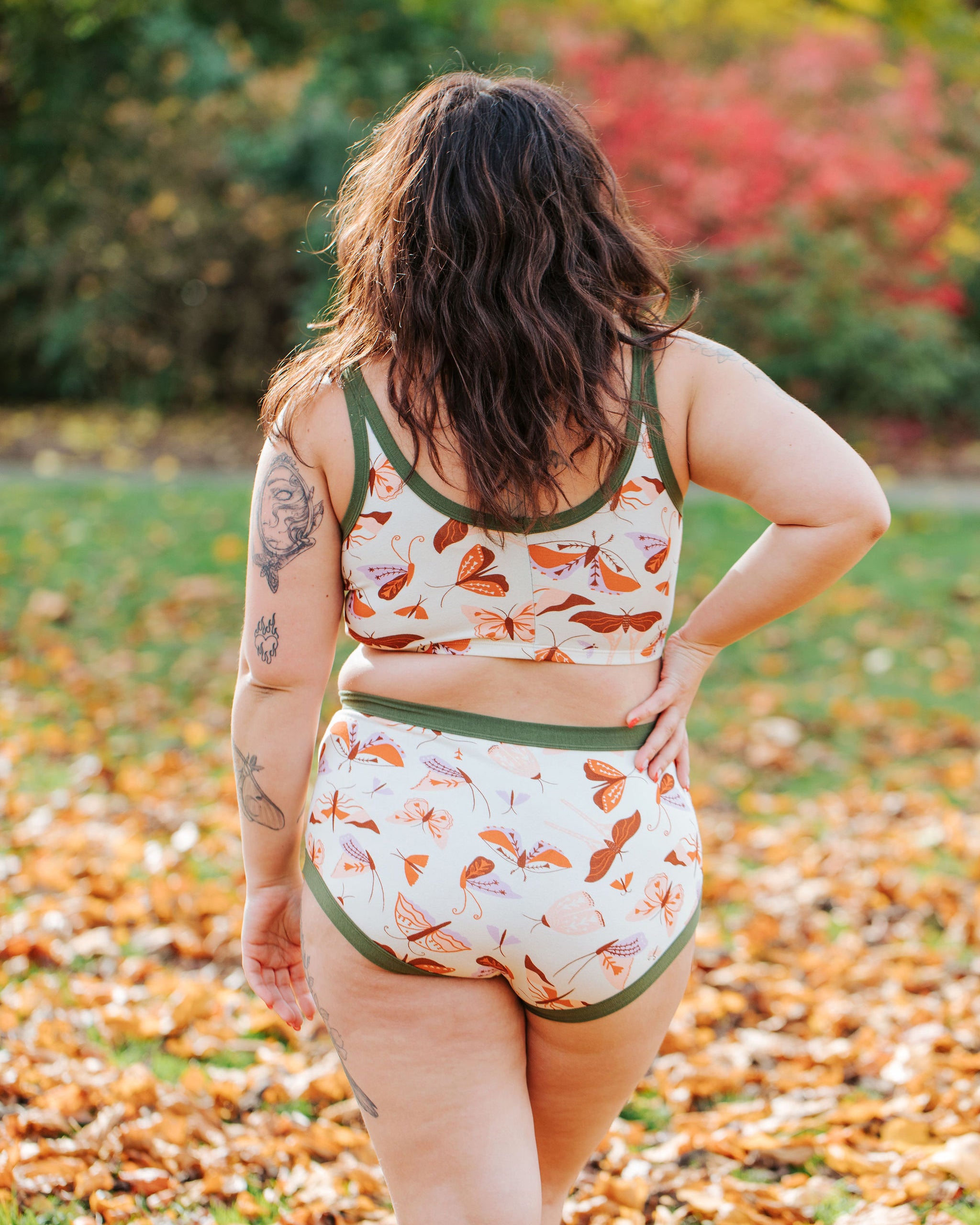 Model wearing Thunderpants Original style underwear and Longline Bra in Field Study: a moth print in red, orange, pink, and purple bound in green.