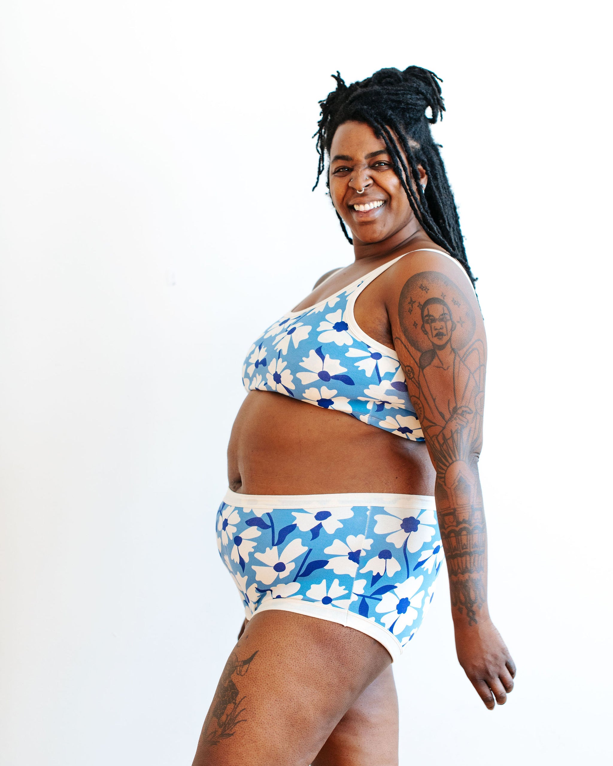 Model wearing Thunderpants Original style underwear and Bralette in Moody Blooms - white and blue flowers with blue background.