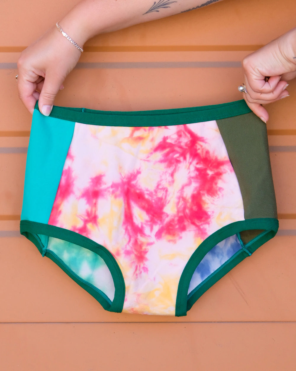 Hand holding a pair of Thunderpants Original style underwear in Dye Scrap Panel Pants - a mix of solids and dyed fabrics.