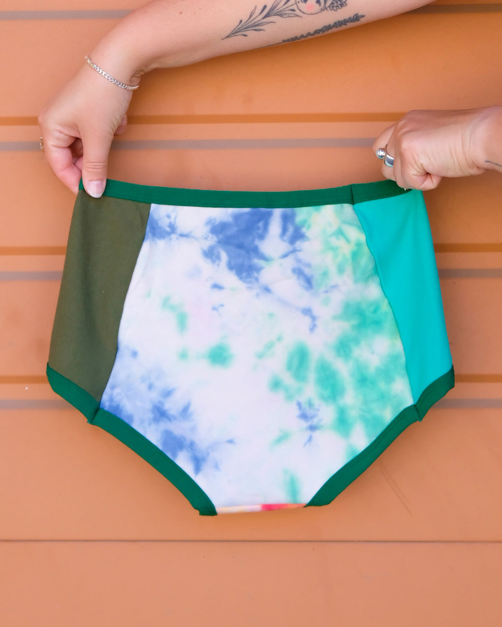 Hand holding a pair of Thunderpants Original style underwear in Dye Scrap Panel Pants - a mix of solids and dyed fabrics.