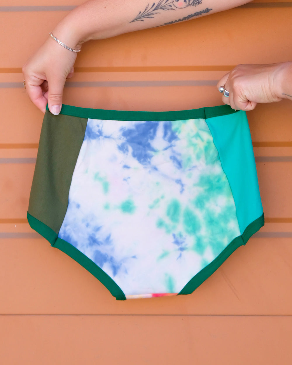 Hand holding a pair of Thunderpants Original style underwear in Dye Scrap Panel Pants - a mix of solids and dyed fabrics.