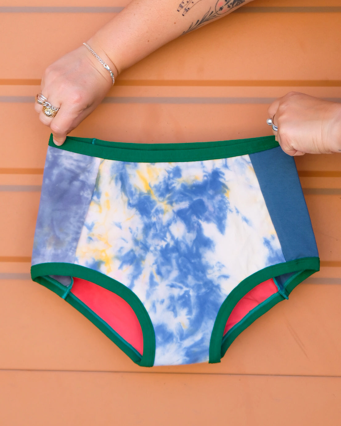 Hand holding a pair of Thunderpants Original style underwear in Dye Scrap Panel Pants - a mix of solids and dyed fabrics.