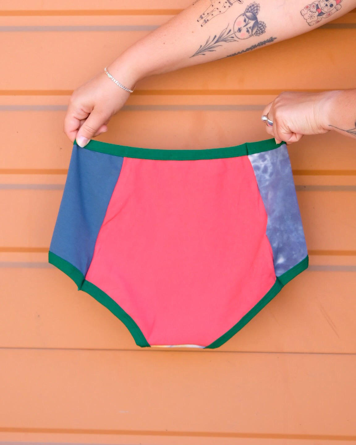 Hand holding a pair of Thunderpants Original style underwear in Dye Scrap Panel Pants - a mix of solids and dyed fabrics.