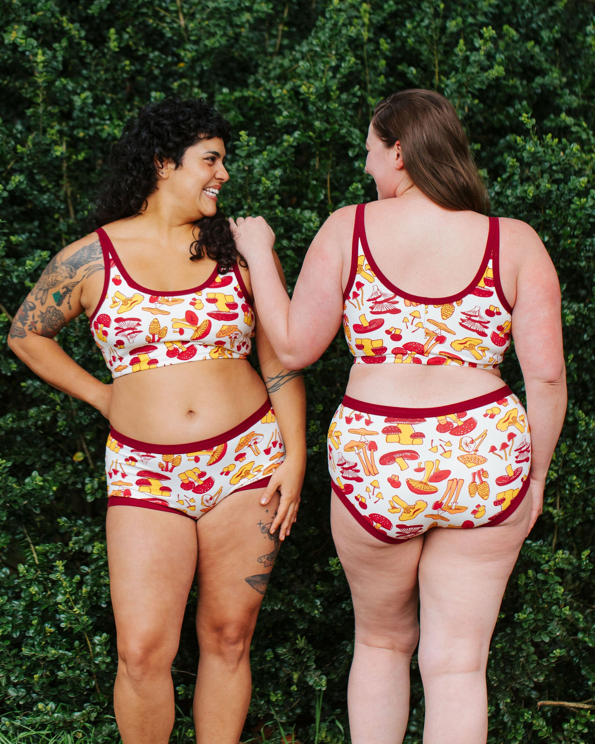 Two models wearing Thunderpants Original style underwear  and Longline Bra in Whadda Fungi - red, orange, and yellow mushroom print.