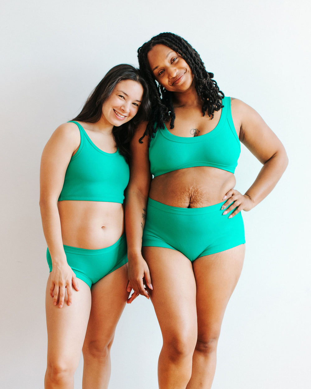 Two models wearing various styles of Thunderpants in Peacock Green.