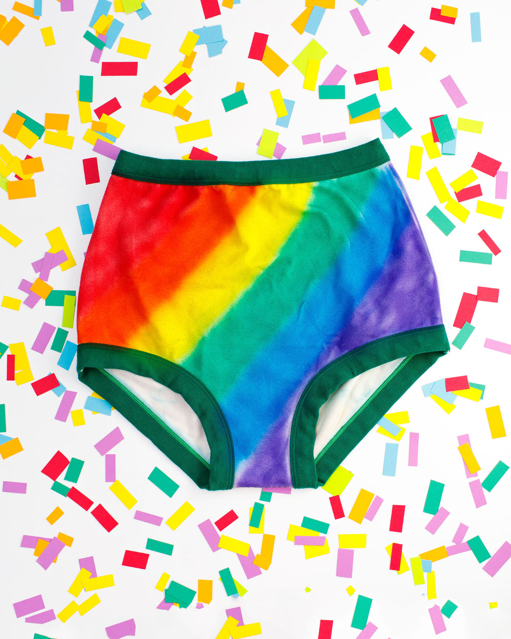 Thunderpants organic cotton Sky Rise style underwear in hand painted rainbow stripes for Pride laying on rainbow confetti.