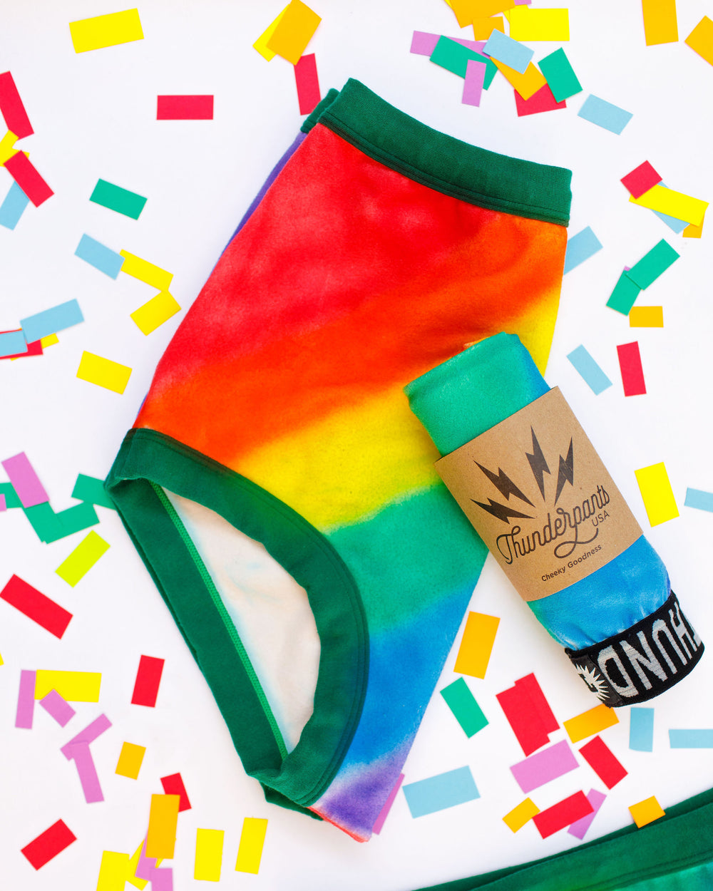 Thunderpants organic cotton Sky Rise style underwear in hand painted rainbow stripes for Pride laying on rainbow confetti.