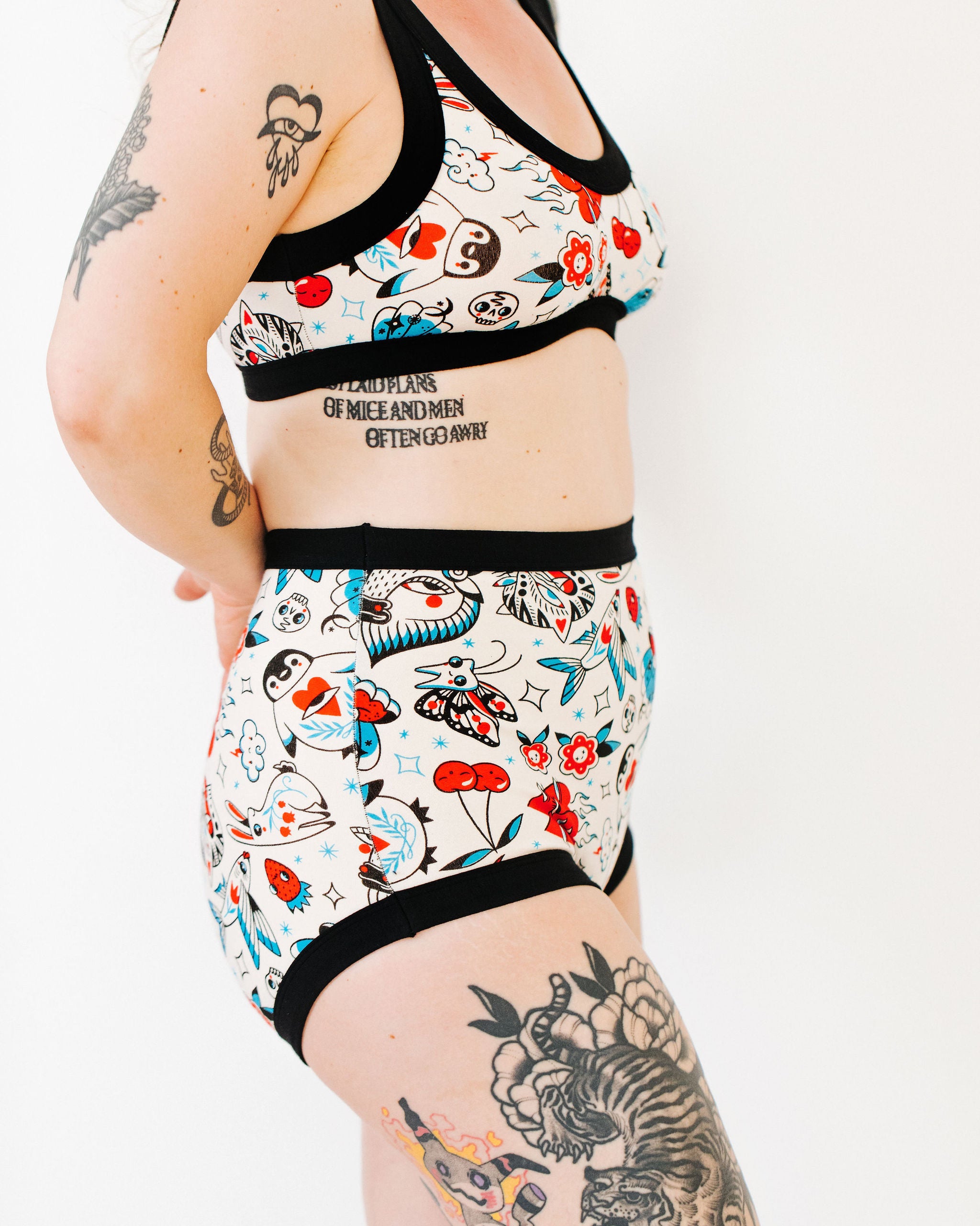 Model wearing Thunderpants Sky Rise style underwear and Bralette in Inked Up - a tattoo pattern with black, red, and blue. 