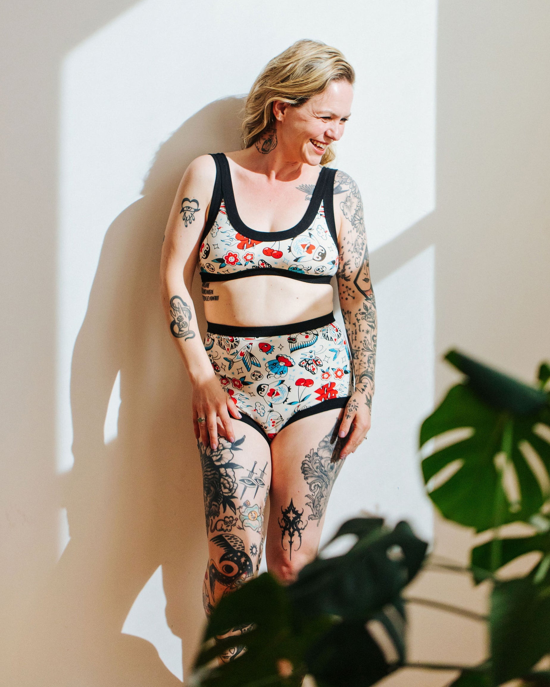 Model wearing Thunderpants Sky Rise style underwear and Bralette in Inked Up - a tattoo pattern with black, red, and blue. 