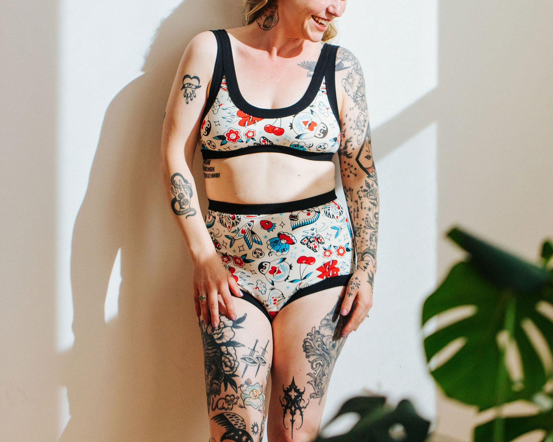 Model wearing Thunderpants Sky Rise style underwear and Bralette in Inked Up - a tattoo pattern with black, red, and blue. 