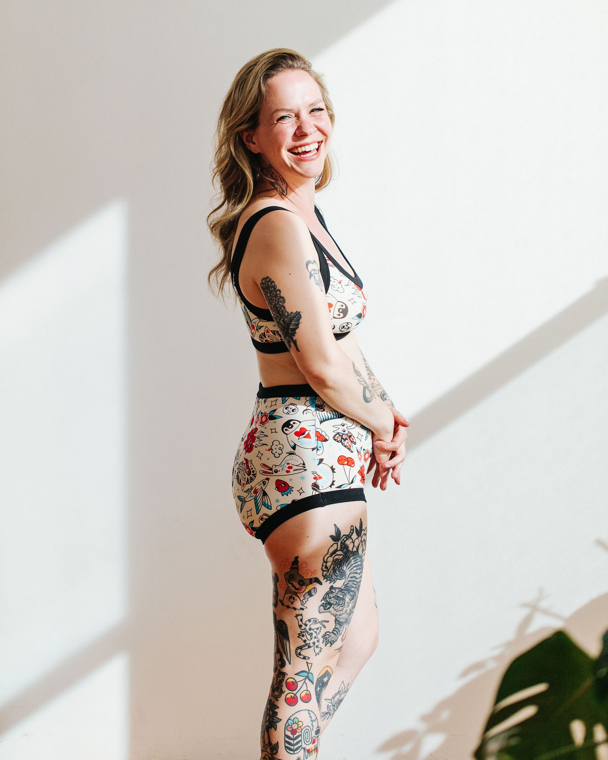 Model wearing Thunderpants Sky Rise style underwear and Bralette in Inked Up - a tattoo pattern with black, red, and blue. 