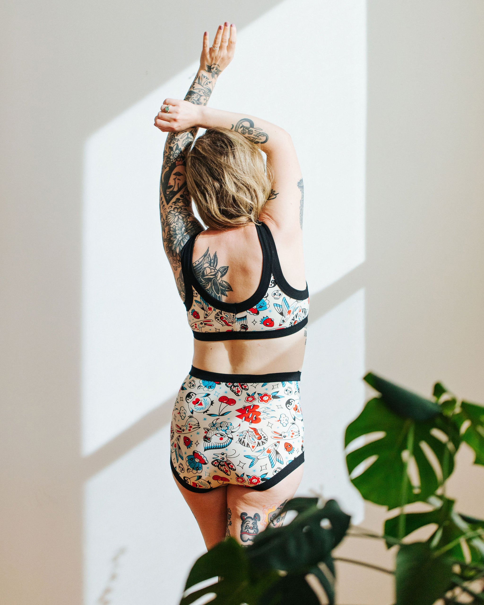 Model wearing Thunderpants Sky Rise style underwear and Bralette in Inked Up - a tattoo pattern with black, red, and blue. 