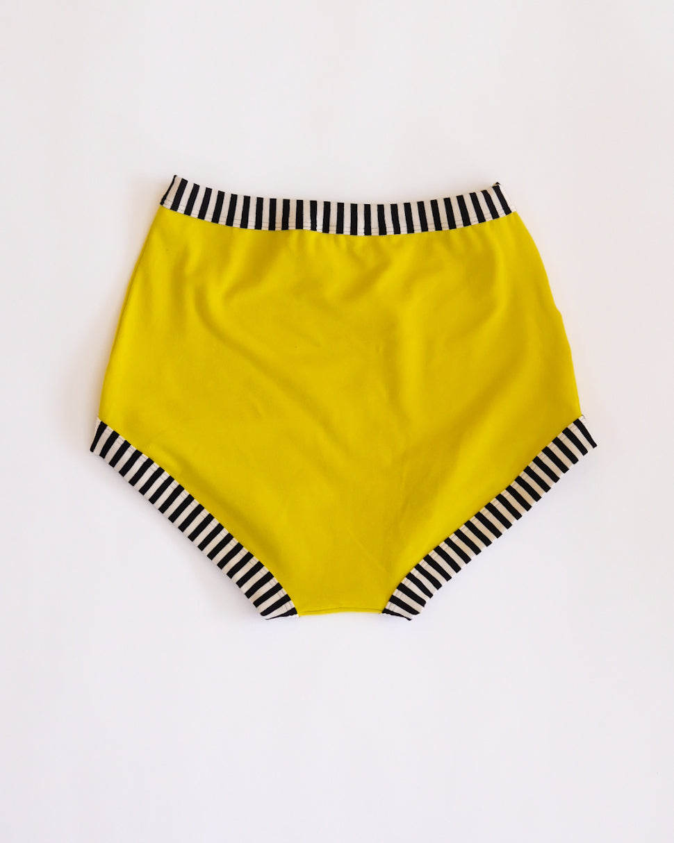 Flat lay of Thunderpants Sky Rise style underwear in Thunderstruck - yellow with a black lightning bolt.