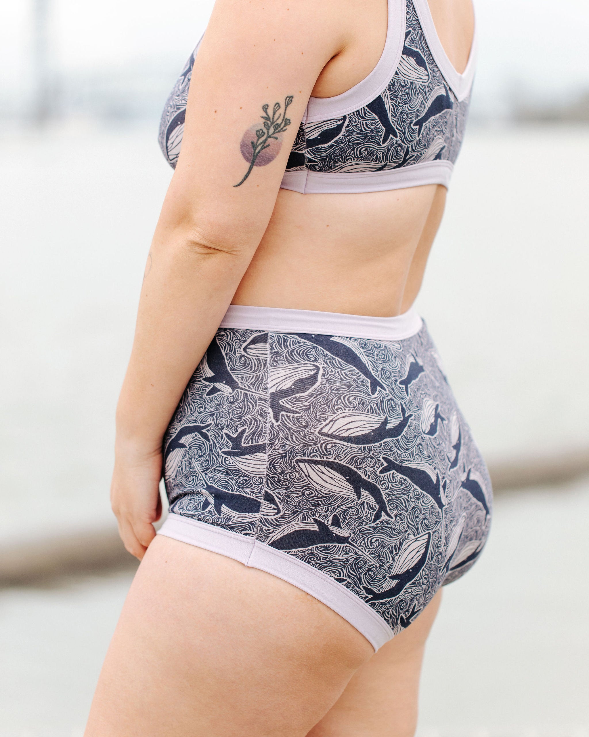 Model wearing Thunderpants Sky Rise style underwear and Bralette in Whale, Whale, Whale print - indigo whales on lavender.