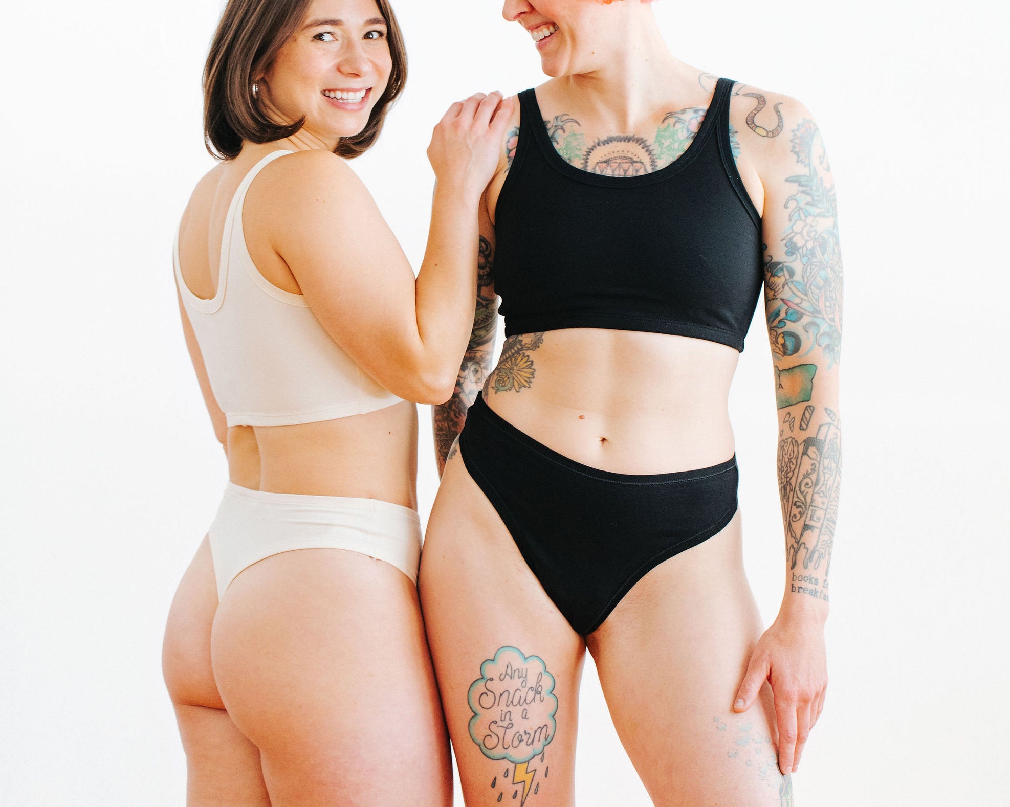 Two models wearing sets in Thunderpants Thong style underwear and Long Line Bra in Plain Vanilla and Plain Black.