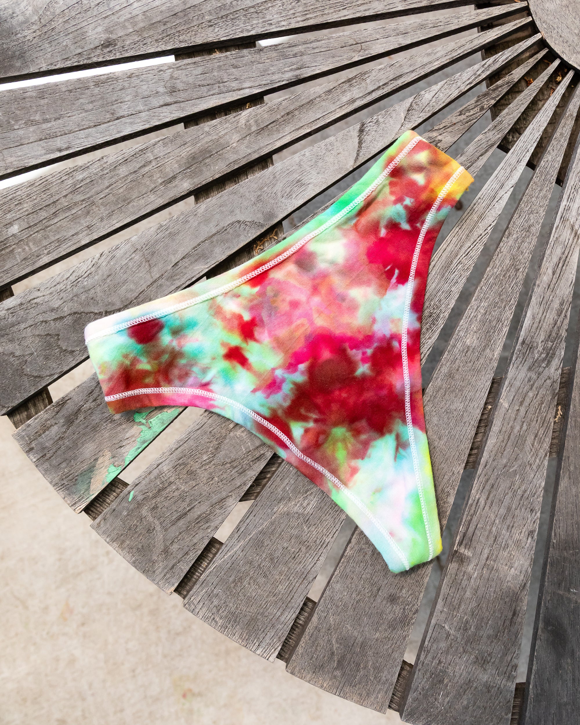 Flat lay of Thunderpants Thong style underwear in Summer Crush Ice Dye - pinks, blues, yellows. 