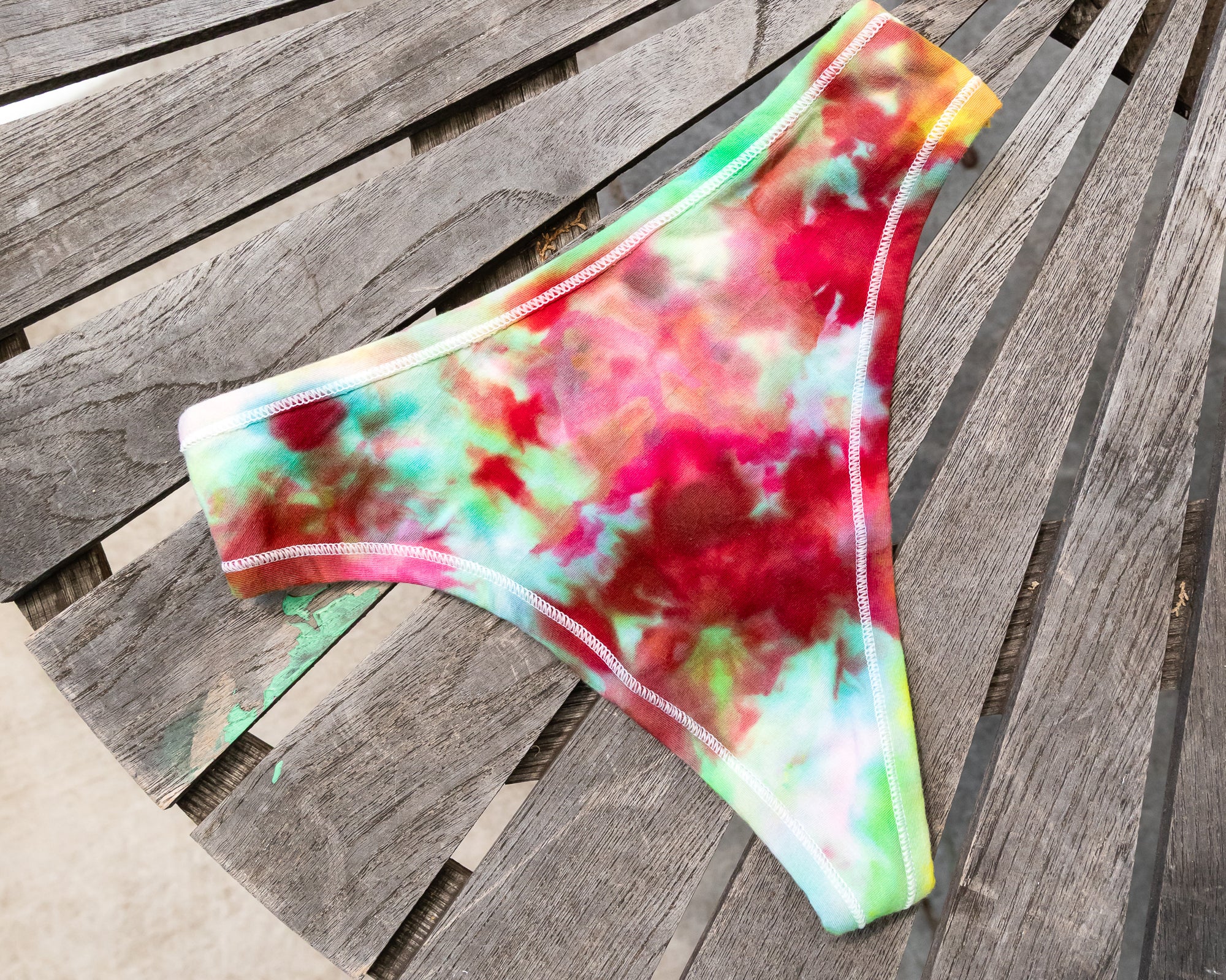 Flat lay of Thunderpants Thong style underwear in Summer Crush Ice Dye - pinks, blues, yellows. 