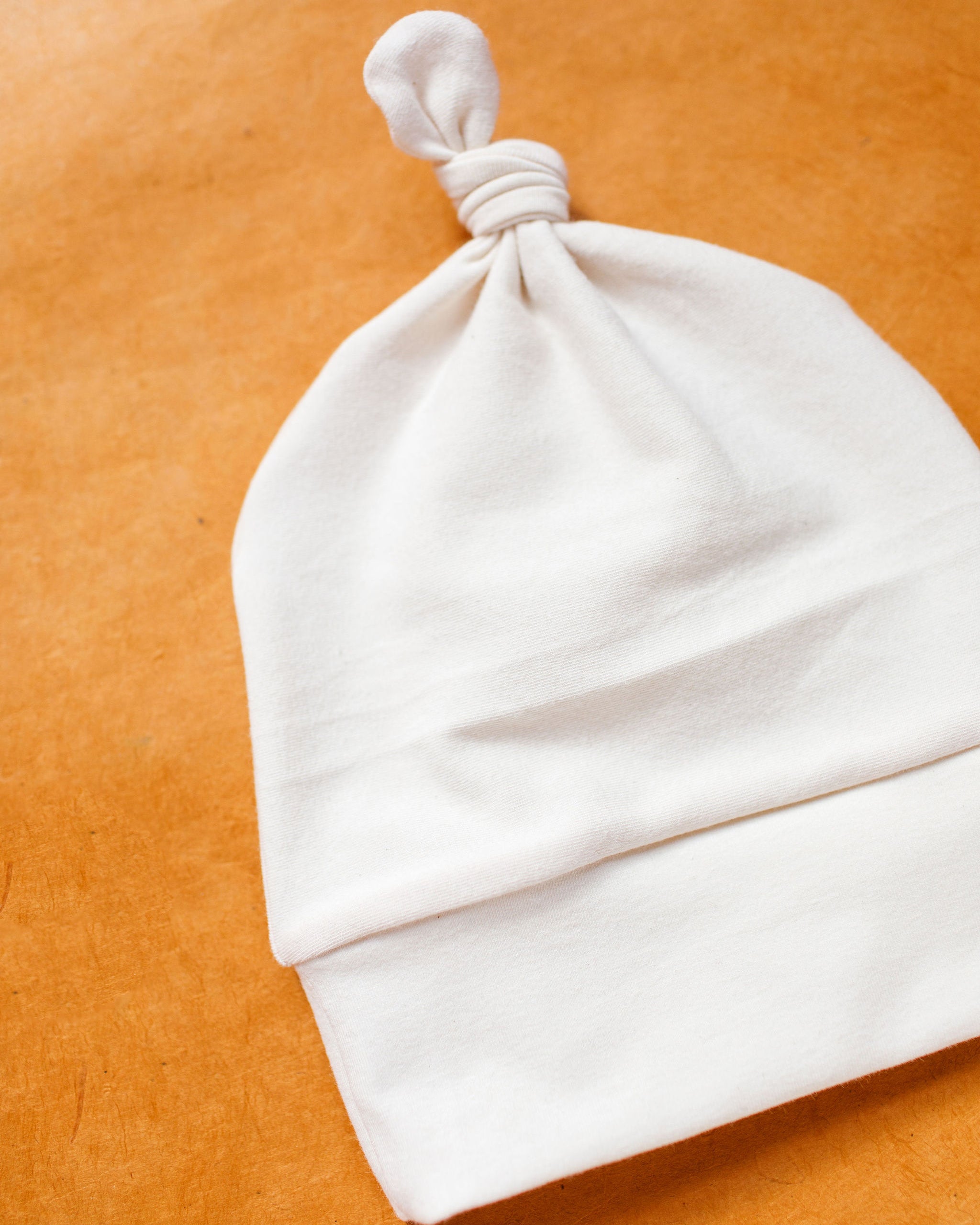 Close up flat lay of Thunderpants Scrap Baby Hat in Plain Vanilla.