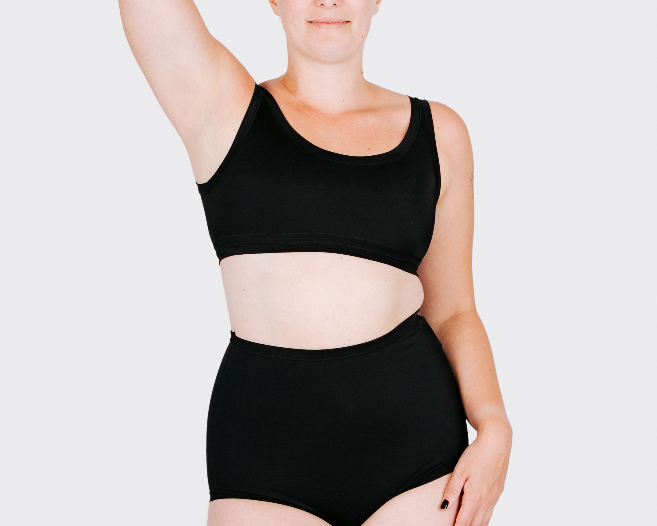 Fit photo from the front of Thunderpants recycled nylon Swimwear Sky Rise style bottoms in Plain Black on a model.